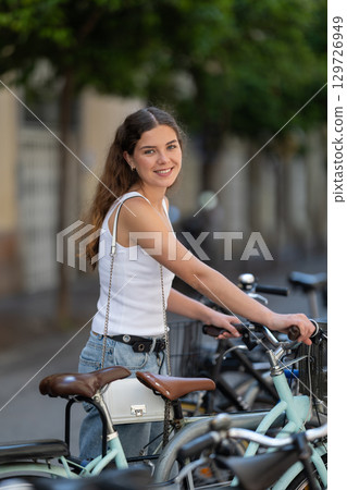 Girl tourist rents bicycle 129726949