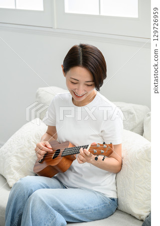一個女人在玩夏威夷四弦琴 一個女人在玩夏威夷四弦琴 129726959