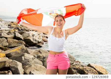Young woman on coast posing with flag of Peru Young woman on coast posing with flag of Peru 129726969