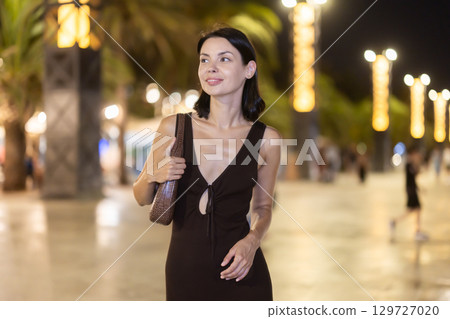 At night, smiling girl walks around old city district Barceloneta, in vicinage of Citadel Park At night, smiling girl walks around old city district Barceloneta, in vicinage of Citadel Park 129727020