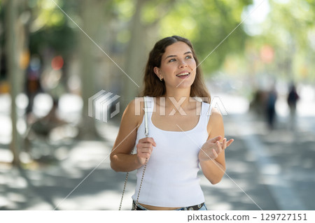 Young smiling girl walks along city street 129727151
