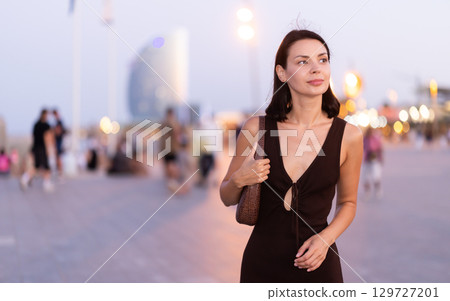 Young woman walking on a lively promenade of Barceloneta Young woman walking on a lively promenade of Barceloneta 129727201