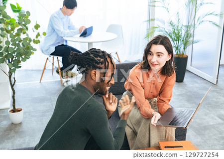 Multinational people talking while looking at laptops in the lobby Multinational people talking while looking at laptops in the lobby 129727254