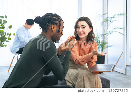 Multinational people talking while looking at laptops in the lobby Multinational people talking while looking at laptops in the lobby 129727255