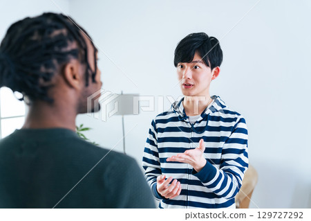 A Japanese man talking to a foreign man 129727292