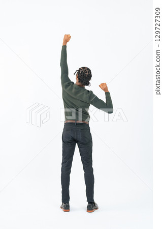 Full-body photo of a black man posing with his fist in the air Full-body photo of a black man posing with his fist in the air 129727309