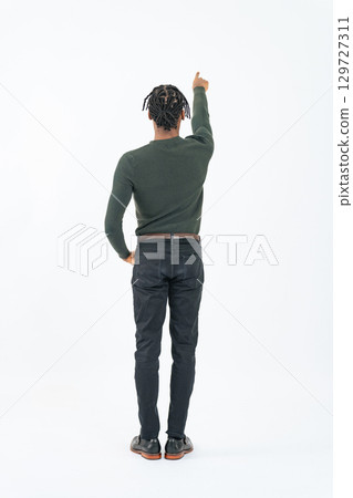 Full-body photo of a pointing black man from behind Full-body photo of a pointing black man from behind 129727311