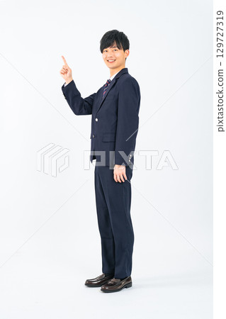 Full-body photo of a male student pointing at a white background 129727319