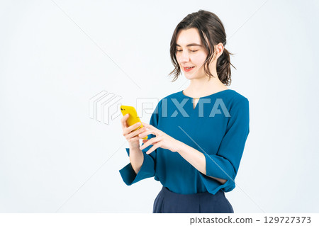 Full body photo of a white woman using a smartphone Full body photo of a white woman using a smartphone 129727373