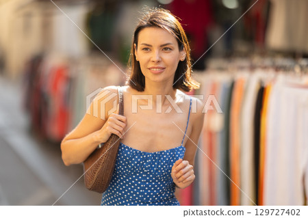 Young woman looks around at street market 129727402