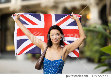Young woman with UK flag on city street 129727444
