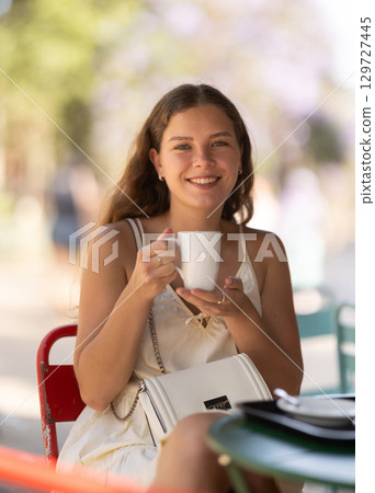 Young woman drinking tea in cafe Young woman drinking tea in cafe 129727445