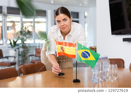 female assistant prepares conference room for diplomats of Brazil and Spain female assistant prepares conference room for diplomats of Brazil and Spain 129727619