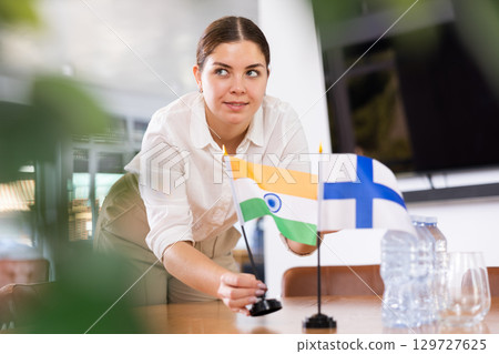 female assistant prepares conference room for diplomats of Finland and India female assistant prepares conference room for diplomats of Finland and India 129727625