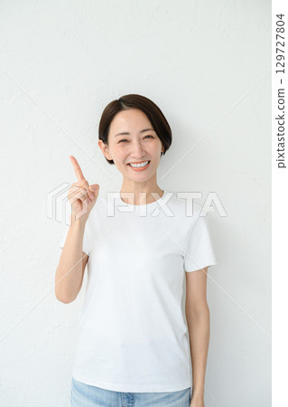 A woman doing a pointing pose A woman doing a pointing pose 129727804