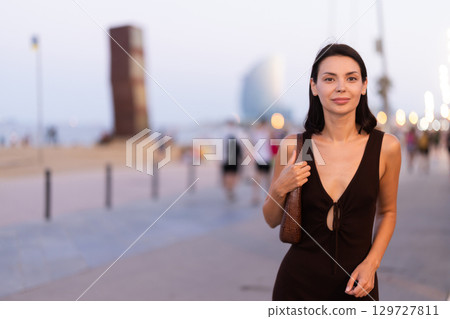 Smiling girl walks around old city district Barceloneta, pedestrian promenade embankment. Smiling girl walks around old city district Barceloneta, pedestrian promenade embankment. 129727811