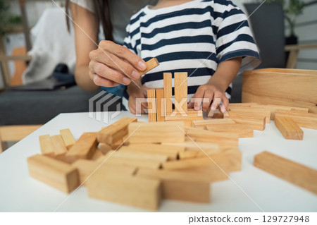 Creative Play. Mother helping child build with wooden blocks at home. Creative Play. Mother helping child build with wooden blocks at home. 129727948