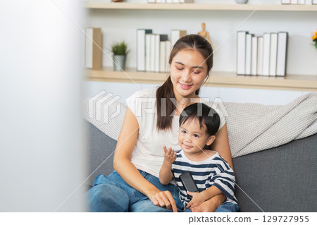 Mother and son enjoying screen time together at home 129727955