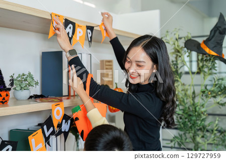 Halloween Celebration. A mother and son happily decorating their home for Halloween. 129727959