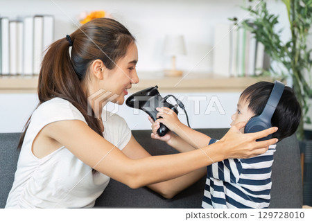 Interactive Gaming: Mother and Child Sharing Headphones 129728010