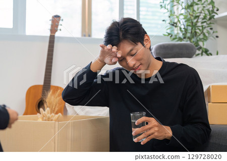 Father taking a break while unpacking, reflecting on family life 129728020