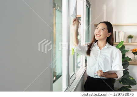 Office Productivity. Young woman organizing workspace and enhancing efficiency. 129728076