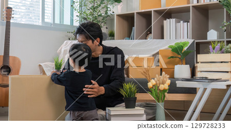 Father and son sharing a moment while arranging plants at home Father and son sharing a moment while arranging plants at home 129728233