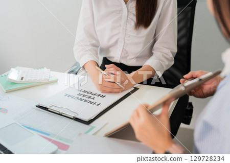 Financial Planning. Professional woman reviewing a financial report in the office. 129728234