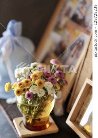 Small chrysanthemum flowers displayed in front of a pet's altar 129729239