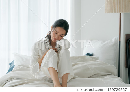 A woman in pajamas who is unwell 129729837