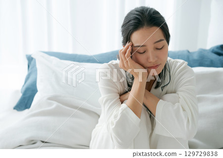 A woman waking up with a tired look 129729838