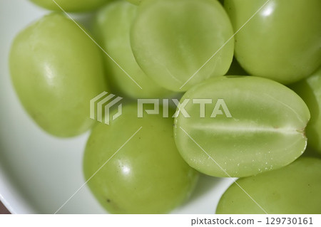 Japanese Shine Muscat grapes, removed from the bunch and cut in half lengthwise Japanese Shine Muscat grapes, removed from the bunch and cut in half lengthwise 129730161
