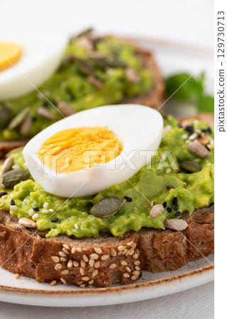 Avocado toast with boiled egg, sunflower seeds, pumpkin seeds and sesame seeds Avocado toast with boiled egg, sunflower seeds, pumpkin seeds and sesame seeds 129730713