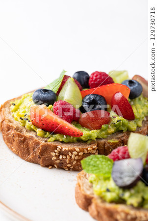 Avocado toast with strawberry, blueberry, raspberry and grape. Healthy eating 129730718