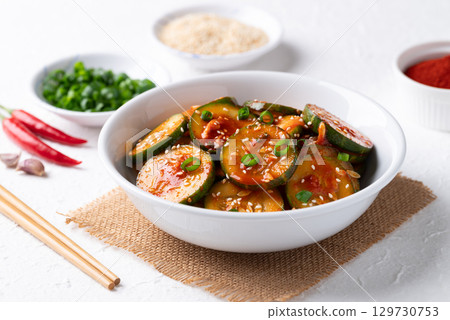 Korean cucumber salad (Oi muchim) in bowl on white background, Korean side dish Korean cucumber salad (Oi muchim) in bowl on white background, Korean side dish 129730753