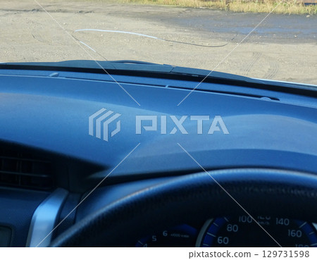 Cracks in the windshield of a car caused by flying stones 129731598