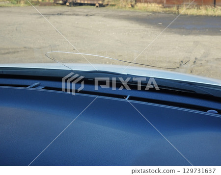 Cracks in the windshield of a car caused by flying stones Cracks in the windshield of a car caused by flying stones 129731637