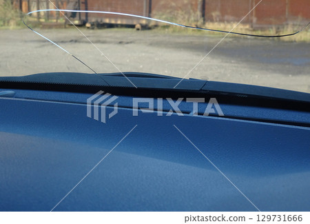 Cracks in the windshield of a car caused by flying stones Cracks in the windshield of a car caused by flying stones 129731666