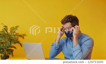 man working from home wearing a face mask 129731695
