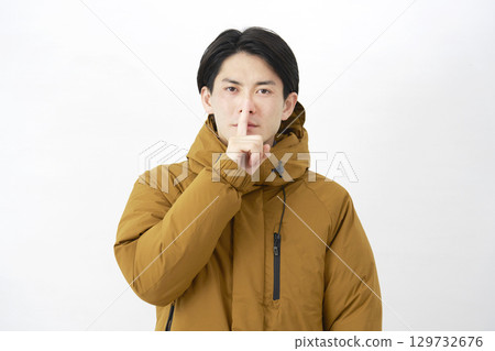 Man wearing down jacket, secret gesture, white background Man wearing down jacket, secret gesture, white background 129732676