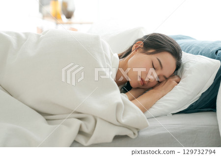 一個睡在床上的年輕女人 129732794