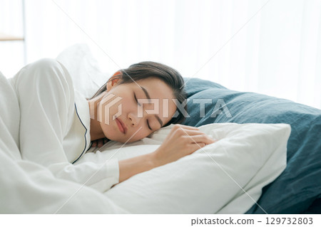 一個睡在床上的年輕女人 129732803