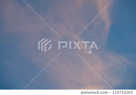 Clouds and the moon floating in the evening blue sky 129733263