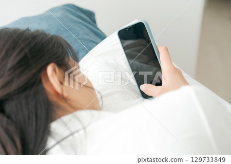 使用智能手機的少婦在床上 129733849