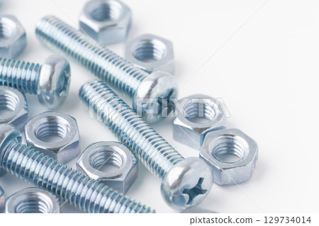 Pan head screws (cross recess) and nuts on a white background Pan head screws (cross recess) and nuts on a white background 129734014