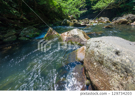 Beautiful valley with flowing water and rocks 129734203