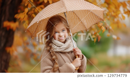Young caucasian girl with umbrella in autumn park. 129734779