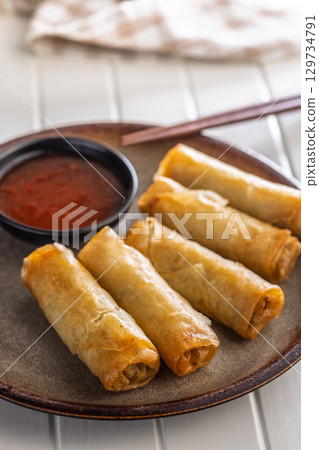 Fried spring rolls with sweet and saur sauce on white table. 129734791