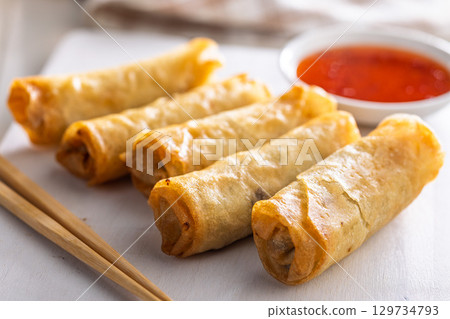 Fried spring rolls with sweet and saur sauce on white table. 129734793