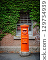 Red mailbox, bricks and green vines 129734939
